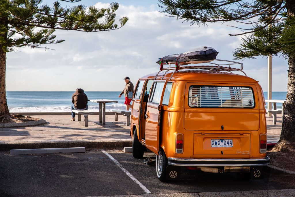 orange van parked in front of ocean view