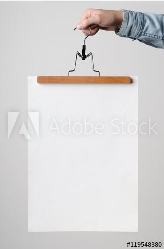 a blank poster is being held by a hand and a hanger
