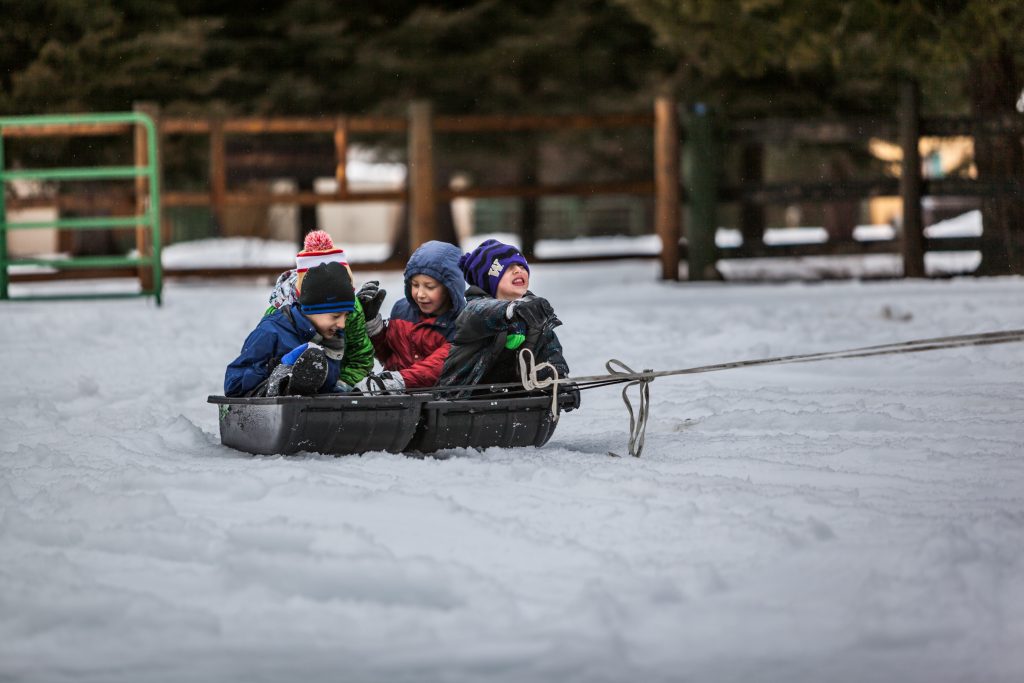 children being pulled on a sled